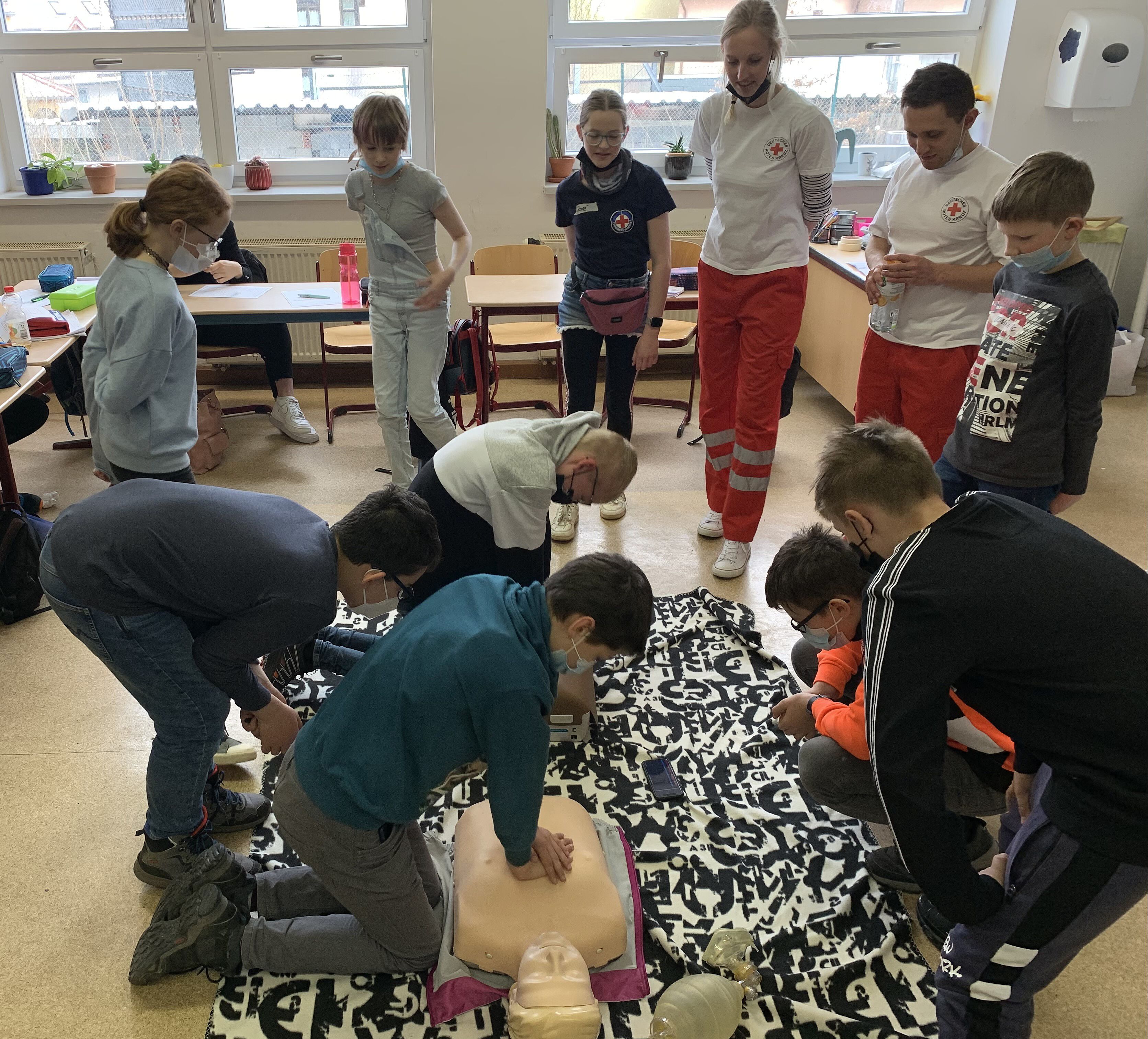 Der 6. Jahrgang Robben und Eisbären der Jenaplan-Schule beim Üben der Herzdruckmassage